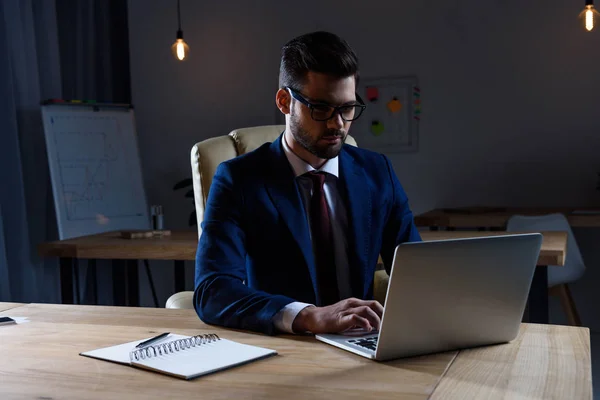 Schöner Geschäftsmann, der nachts im Büro arbeitet — Stockfoto