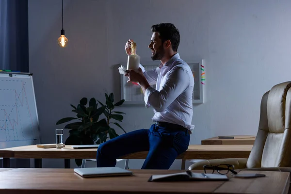 Голодний бізнесмен їсть локшину з паличками в офісі — стокове фото