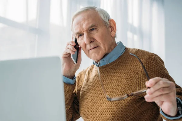 Senior hombre ocupado trabajando en la oficina y haciendo llamadas telefónicas - foto de stock