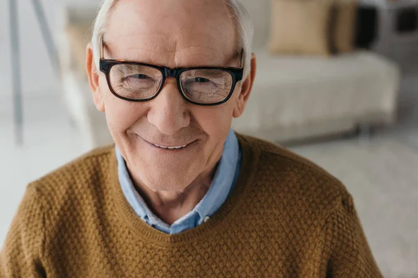 Hombre sonriente mayor con anteojos y mirando a la cámara - foto de stock