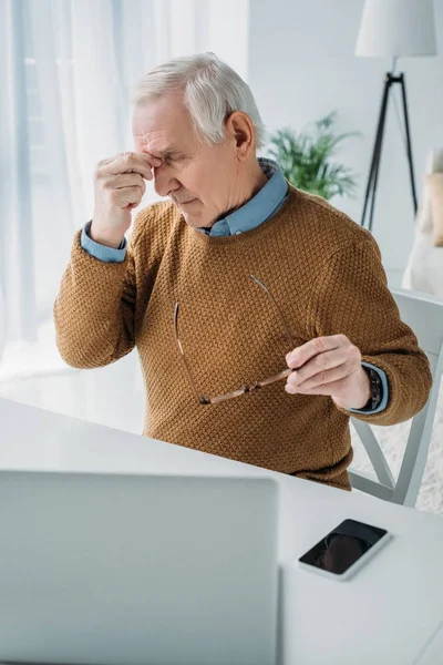 Senior man getting tired from working on laptop — Stock Photo