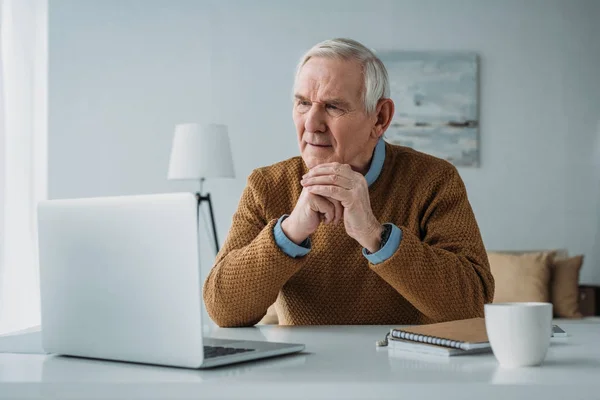 Uomo anziano fiducioso che lavora sul computer portatile — Foto stock