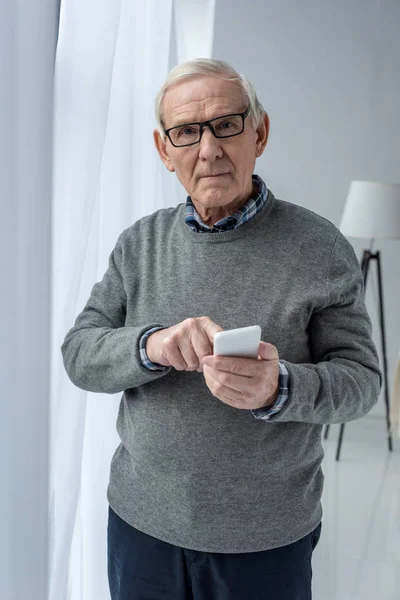 Senior selbstbewusster Mann mit Brille nutzt Smartphone — Stockfoto