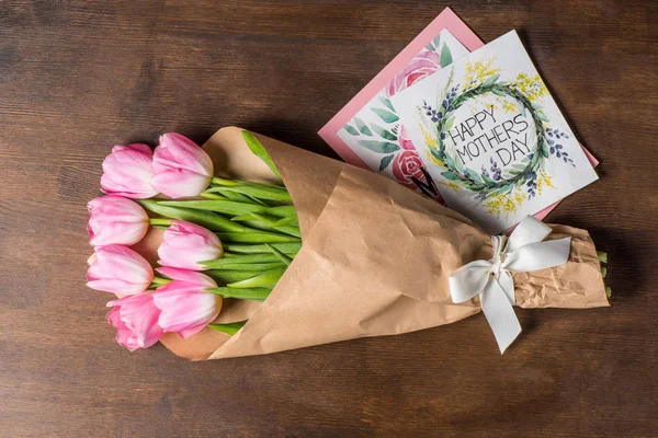 Pink tulips bouquet and postcards — Stock Photo, Image