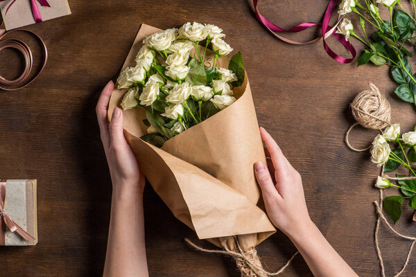 hands holding roses bouquet