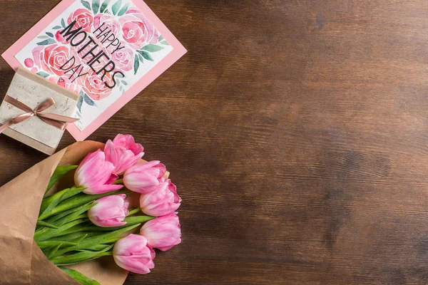 Букет тюльпанов, открытка и подарок — стоковое фото