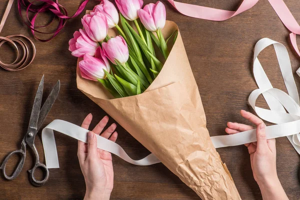 Розовые тюльпаны и руки с лентой — стоковое фото