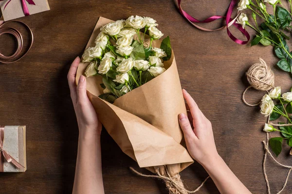 Mains tenant bouquet de roses — Photo de stock