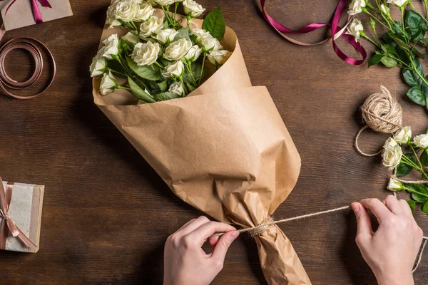Mains attachant corde sur bouquet — Photo de stock