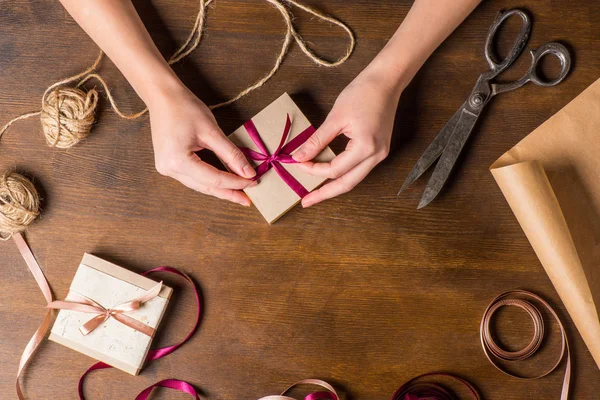 Hands tying ribbon on gift — Stock Photo