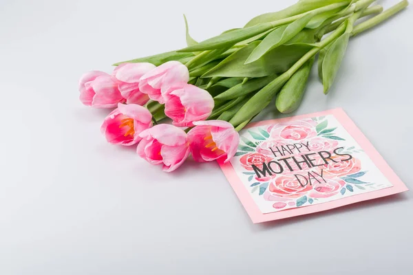 Pink tulips and postcard — Stock Photo