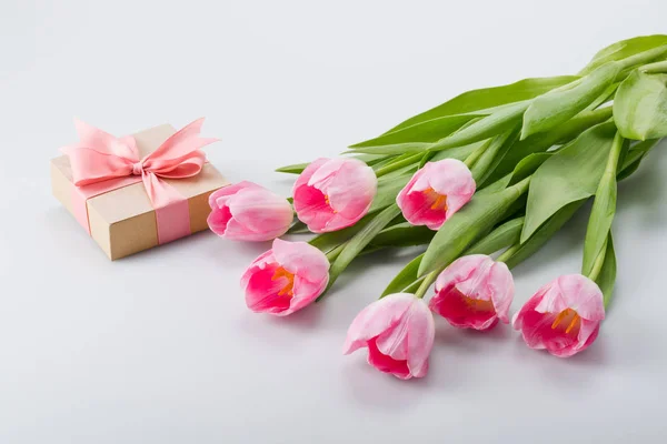 Розовые тюльпаны и подарок — стоковое фото