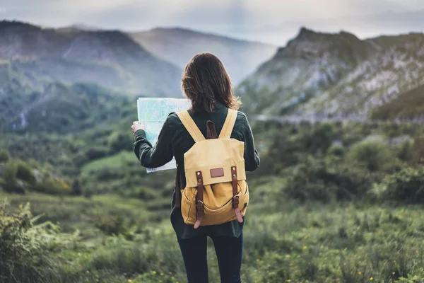 girl with bright backpack holding map