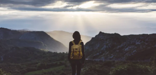 girl with bright backpack enjoying sunset