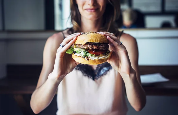 young girl holding burger