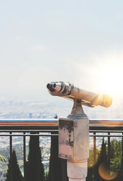 old metal binoculars overlooking cityscape