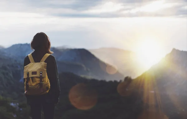 girl with bright backpack enjoying sunset