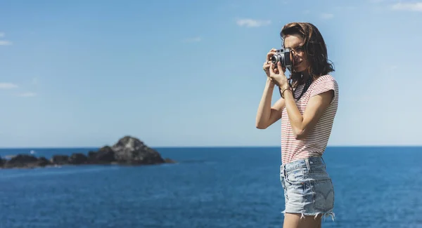 Tourist traveler photographer making pictures sea