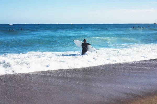 Surfer girl holding surfboard on background sea