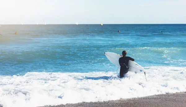 Surfer girl holding surfboard on background sea