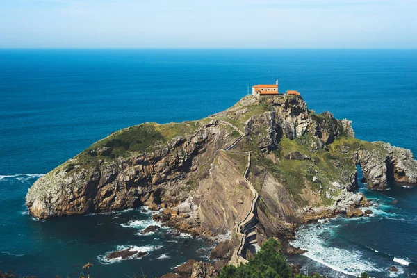 Sea scape on background gaztelugatxe steps sun huan, hipster girl looking on nature horizon ocean, relax holiday, blank space blue waves view, travel trip on Basque country in Spain, popular place of movies