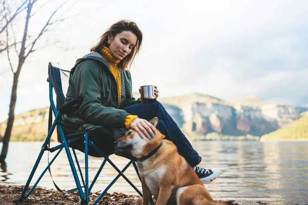 tourist traveler drink tea girl relax together dog on background mountain landscape,  woman hug pet rest on lake shore nature trip