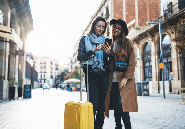 tourist plans trip on internet mobile phone. Travelers using smartphone, hipster travels in Barcelona. Holiday friendship concept. online technology