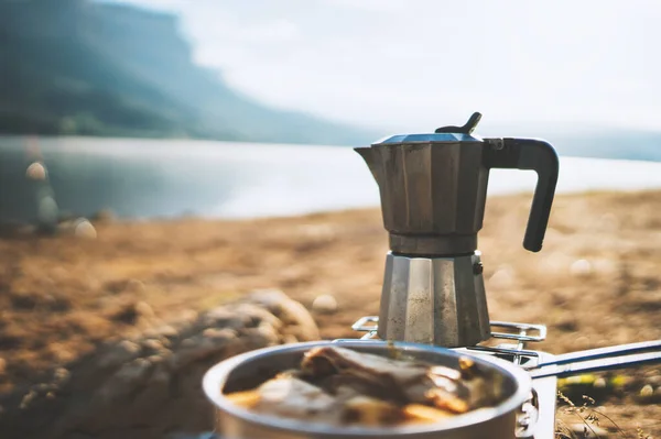 moka pot coffee outdoor in lake, campsite morning picnic lifestyle, cooking hot drink in nature camping, cooker prepare breakfast, tourism recreation outside