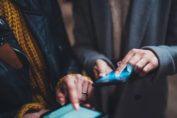 Bloggers together point finger on blue screen smartphone, friends using mobile phone closeup, online wi-fi internet technology, hipster hold in female hands cellphone