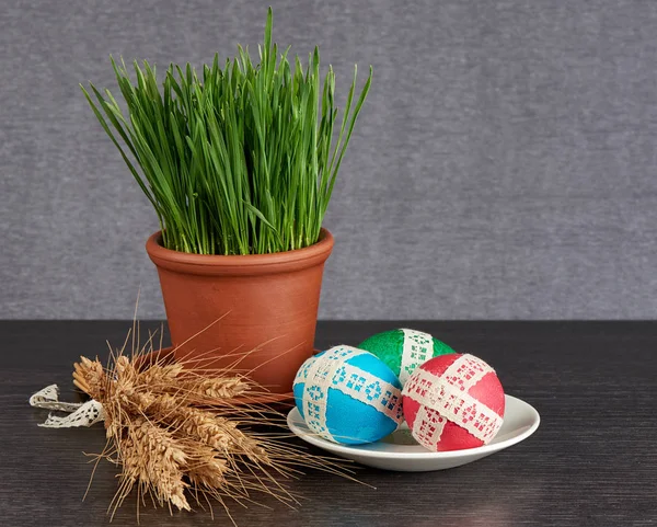 Huevos de pascua en platillo y trigo verde — Foto de Stock