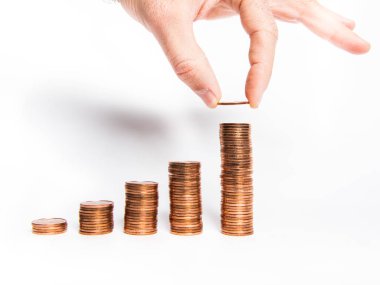 Bozuk para kolonları ve bazılarını düşüren bir el.