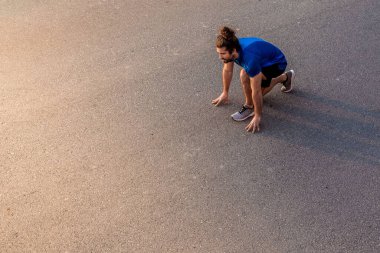 Genç adam koşmaya hazır.