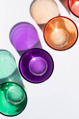 Beyaz arka planda küçük renkli içki bardakları