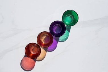 Beyaz arka planda küçük renkli içki bardakları