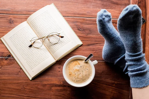 Tasse Kaffee Und Ein Buch Mit Beinen Auf Einem Tisch — Stockfoto