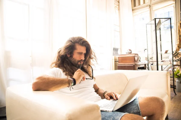 Junger Mann Sitzt Auf Sofa Mit Laptop — Stockfoto