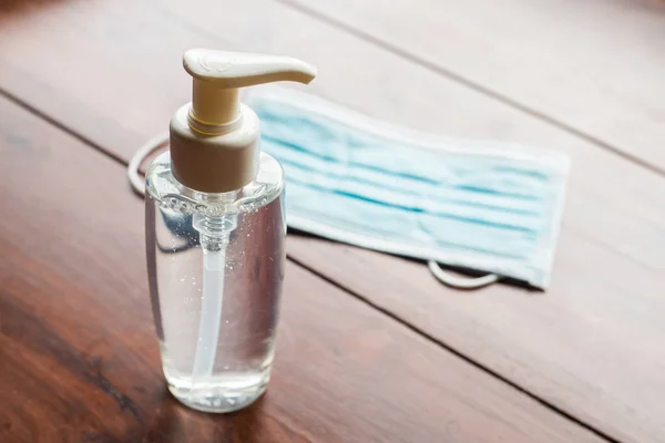 Dispensador Manos Una Máscara Médica Sobre Fondo Madera Fotos De Stock