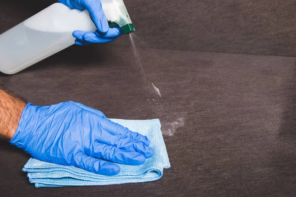 the act of cleaning a surface with gloves and a rag