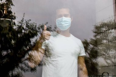 Evinde maske takan genç bir adam.