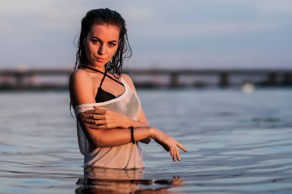 Dziewczyna, przelewanie w wodzie skierowane na zachód słońca — Zdjęcie stockowe