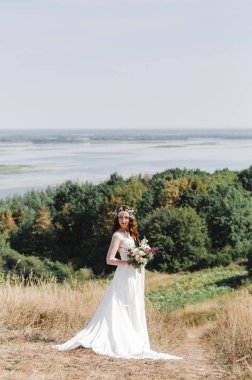 Nehir sızıntısı dağın zirvesinde beyaz bir elbise içinde gelin