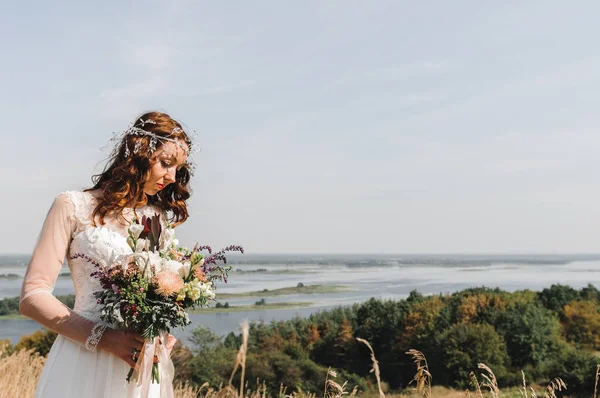 La sposa con un vestito bianco in cima alla montagna fino alla fuoriuscita del fiume — Foto Stock