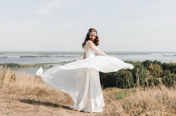 La sposa con un vestito bianco in cima alla montagna fino alla fuoriuscita del fiume — Foto Stock