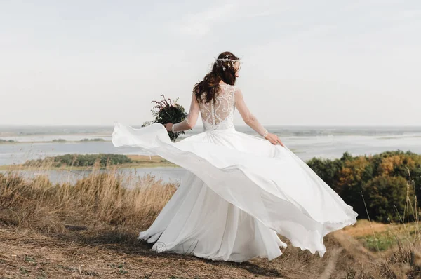 La sposa con un vestito bianco in cima alla montagna fino alla fuoriuscita del fiume — Foto Stock