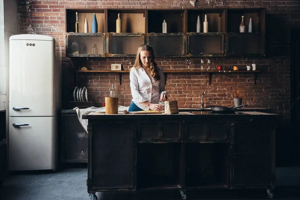 Uma menina na cozinha prepara uma massa — Fotografia de Stock