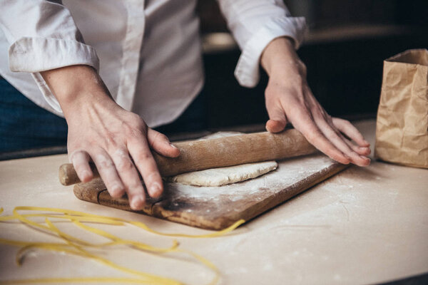 A girl in the kitchen prepares a dough