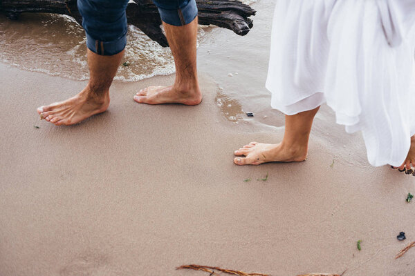 влюбленная пара, идущая барофутом по мокрому песку на пляже i
