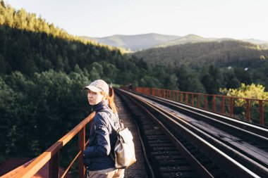 Kız turist üzerinde dağlarda yaz aylarında bir sırt çantası ile bir