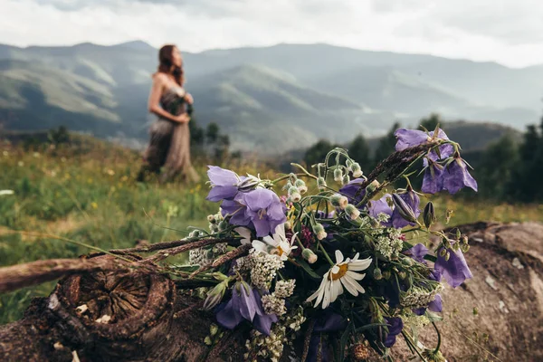 Bouquet di fiori freschi raccolti in montagna. Ragazza sul — Foto Stock