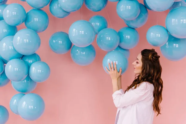 Menina em uma sala rosa com bolas azuis — Fotografia de Stock